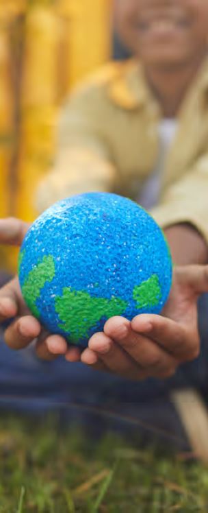 a smiling child holds a small globe