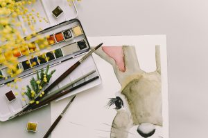 A homemade card depicting a painted rabbit rests on a table. If you have the time, making your own Christmas cards provides a more sustainable and personal option to standard card distribution. | Photo Credit: Leeloo the First from Pexels